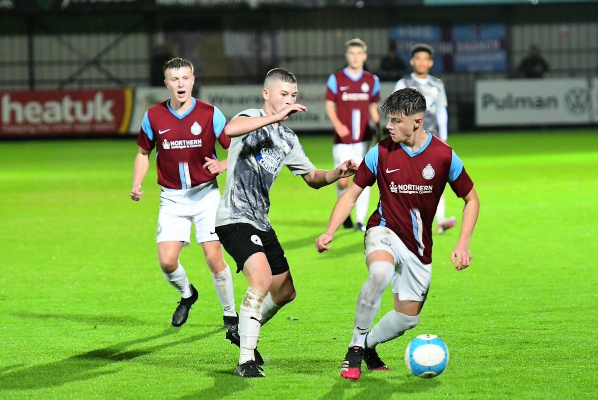 SSFC Academy footballers involved in a tackle during match.