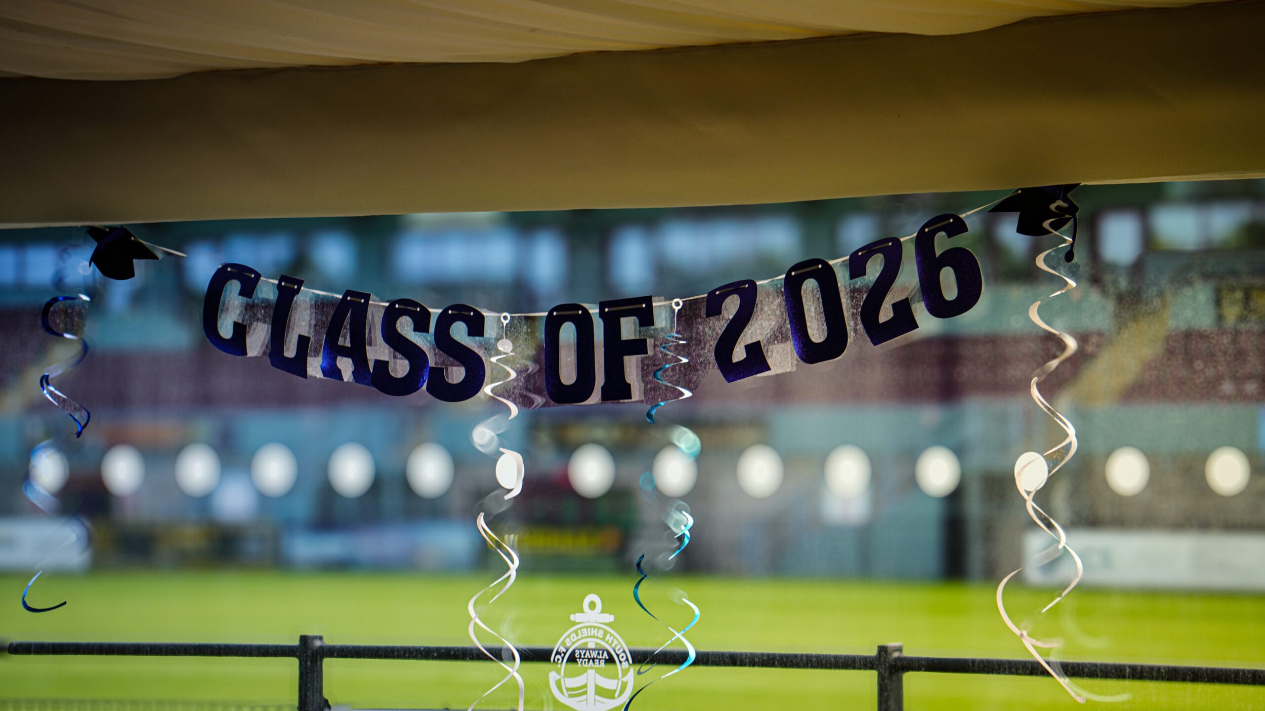 Class of 2026 garland photographed in marquee looking out onto SSFC pitch.